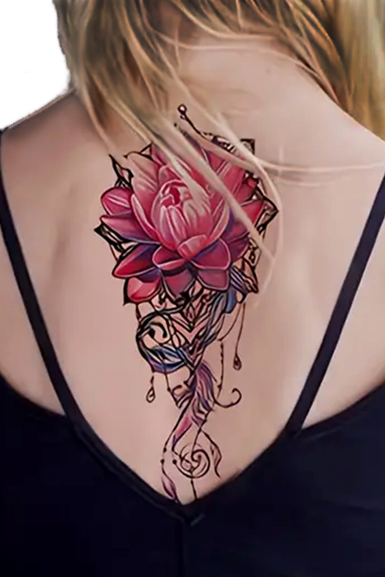 A woman wears the lotus on her back witha low cut shirt. Suppose you want a beautiful tattoo that symbolizes something important to you, whether love or enlightenment, a lotus flower will surely be a perfect choice! Jewels, beads, and feathers honor this lotus flower.