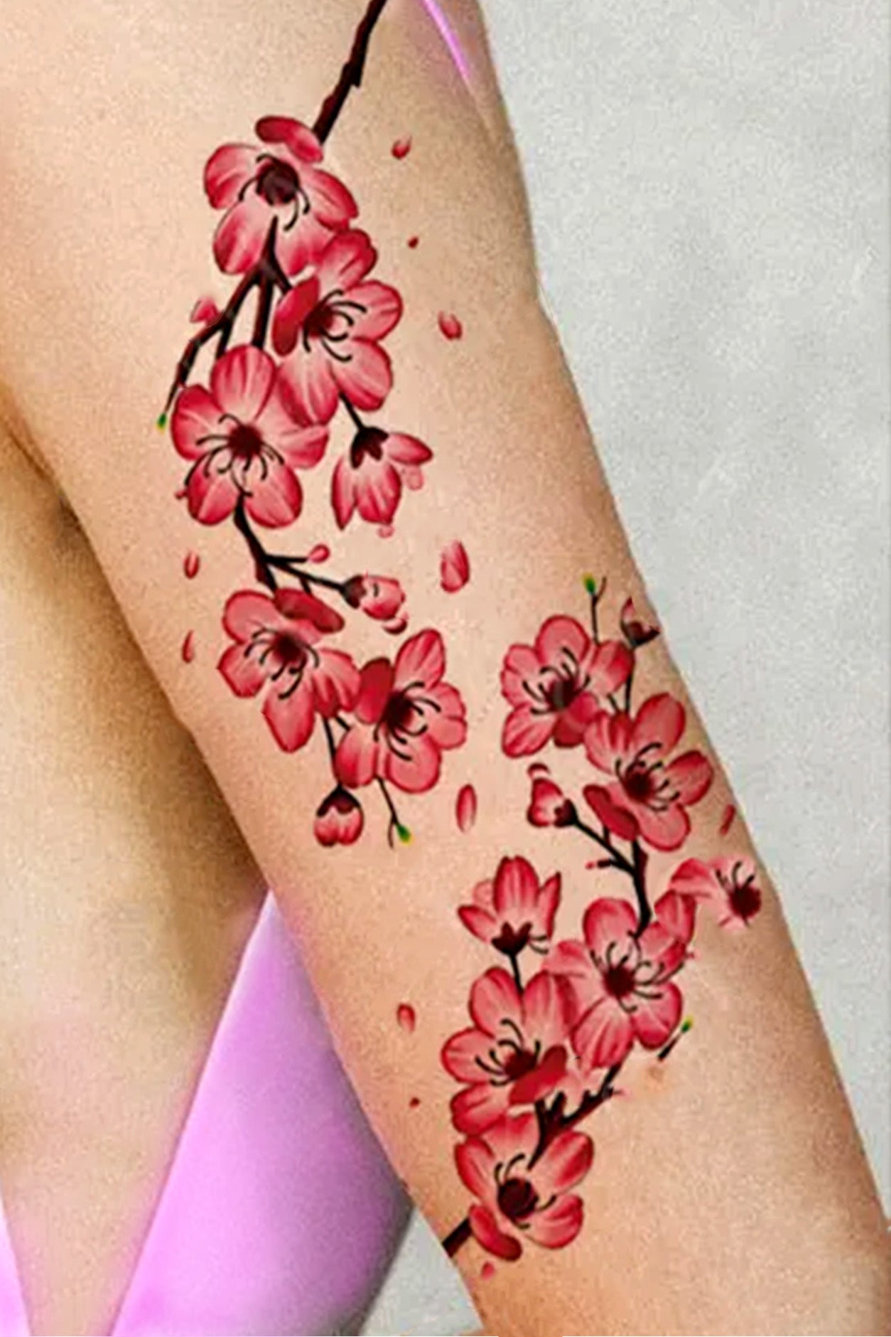 A womans arm shows the upper section with two rows of cherry blossoms. Wear them individually or together. You can also rope them around like a bracelet around arm or leg.