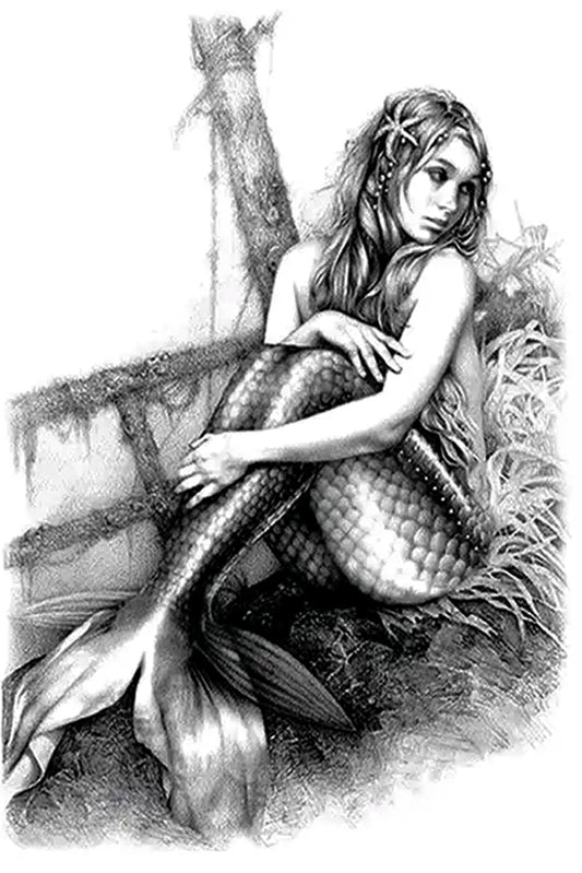 A beautiful mermaid looks with a quizzical expression on land. This highly detailed artwork is as beautiful on the skin. She has seashells in her hair, barnacles on the boat, and every scale shows in her fins. Mermaids symbolize many things; freedom, connection to the ocean, independence, femininity, magic, and sexuality.