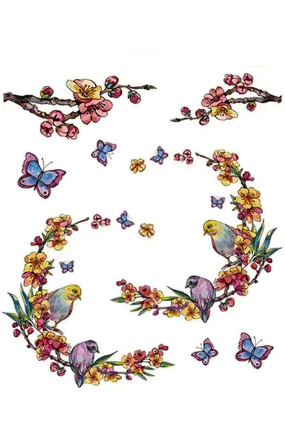 For the flower child in all of us. Gentle pastel flower buds support two parakeet birds. Happy pale blue and lavender butterflies dance around the branches. A bonus of two more branches with early blossoms also compliments this sweet tattoo. Wear this a whole or cut into eight pieces and wear it at different times or locations on your skin.