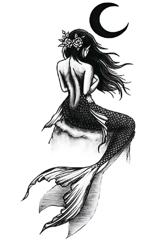 A sexy mermaid sits upon a rock in the light of a waning moon, upon a rock on a windy night. This siren from the deep symbolizes freedom, independence, femininity, magic, and sexuality. A half-fish, half-woman goddess tattoo done in a traditional black ink look.